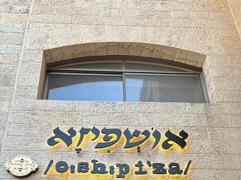 שלט אושפיזא אולם אירועים על קיר אבן ירושלמית